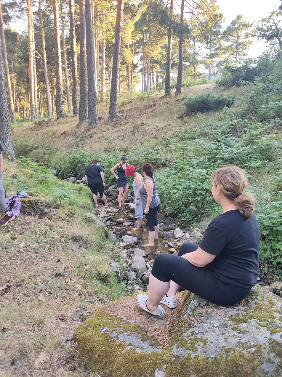 Grupo de mujeres en el arroyo del pinar de El Espinar durante una sesión de baño de bosque, Sierra de Guadarrama, Segovia