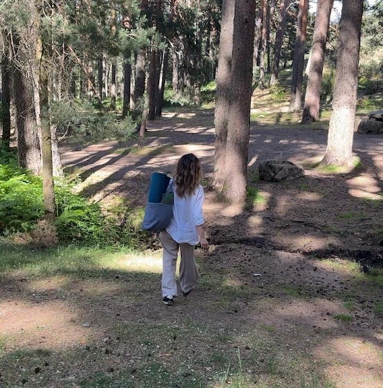 Mujer caminando hacia el bosque por el sendero del pinar de El Espinar